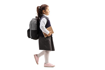 Female pupil with backpack holding book and walking