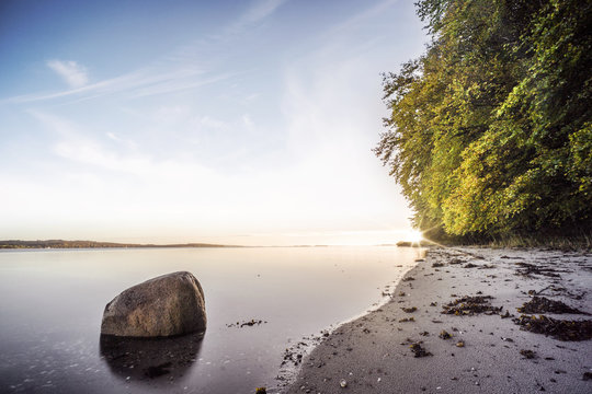 Rock in the calm water on a nordic beach