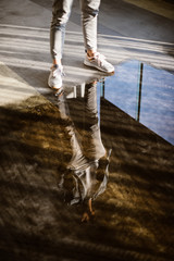 Man standing in front of reflection in puddle