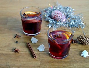 Mulled wine, heated red wine with slices of apple and orange, cinnamon sticks and anise in glass...