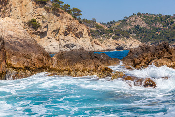 Fototapeta na wymiar sea water splashing rocky coastline on the shores of Tossa De Mar
