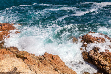 Rocks, waves and surf on Tossa de Mar beach