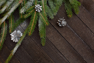 Christmas texture dark wooden background with fir branches and cones