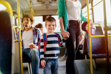 Picture of cute little boy in a bus. Looking at he camera and holding his mothers hand. © Dusan Petkovic