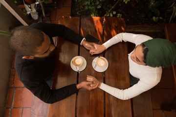 Couple holding hand in cafe