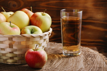 apple juice with apple basket on dark background with glass of juice. autumn coming