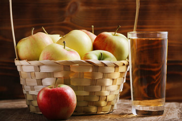 apple juice with apple basket on dark background with glass of juice. autumn coming