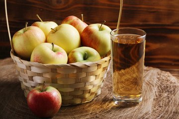 apple juice with apple basket on dark background with glass of juice. autumn coming
