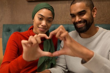 Couple making heart symbol with hands