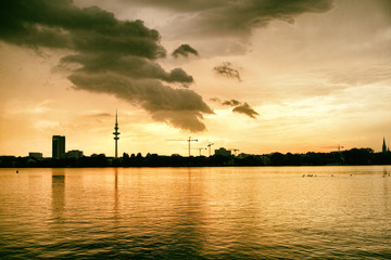 Fototapeta premium Alster Lake in Hamburg Germany View at beautiful and famous city park people rowing sailing panorama sky cloud