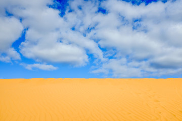 Background image of blue sky with fluffy clouds and sand in Australia, with copy space