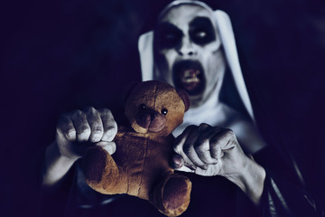 frightening evil nun with a teddy bear