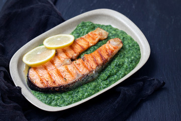 grilled salmon with lemon and spinach on dish