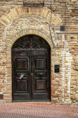 Fototapeta na wymiar Tuscan wooden doorway and wall, Certaldo