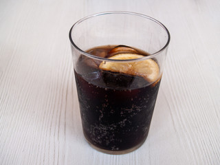 A glass of coke with a slice of lemon