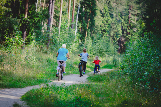 active senior grandmother with kids riding bikes in nature
