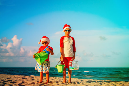 happy kids play with toys on beach at christmas, holiday travel