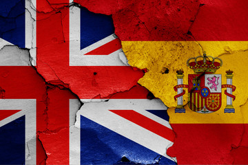 flags of UK and Spain painted on cracked wall