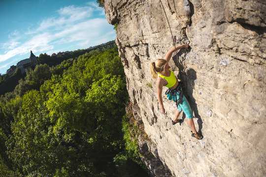 The woman climbs the rock.