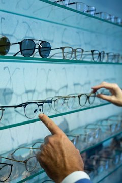 Man and woman's hands selecting frame in clinic
