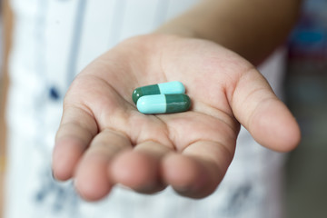 capsules of medicine for anti biotic, blue and green capsules in my hand.