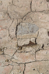 white wall in cement with large cracks and cement chips