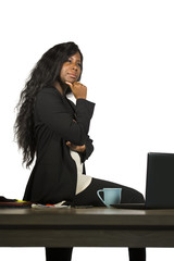 office corporate company portrait of young happy and attractive black African American businesswoman standing at her computer desk thoughtful and pensive