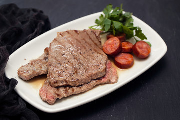 grilled meat with smoked sausage on white dish
