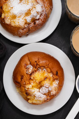 portuguese sweets with coconut Pao de Deus and coffee with milk on black background