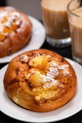 portuguese sweets with coconut Pao de Deus and coffee with milk on black background