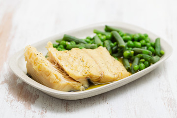 cod fish with green beans and peas on dish