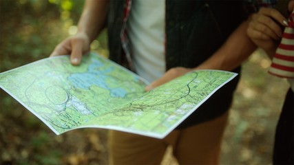 Traveler map in the hands of backpacker in the forest