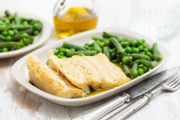 cod fish with green beans and peas on dish