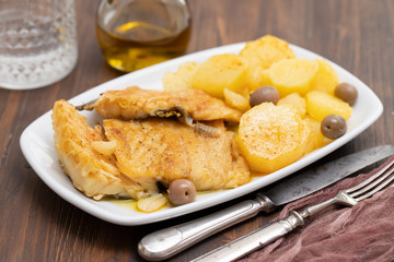 cod fish with fried potato on white dish