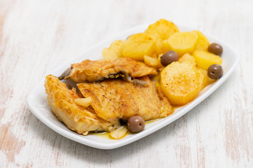 cod fish with fried potato on white dish