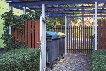 Typical for Germany, a place for separate collection of garbage in a closed building near a house.
