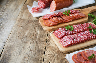 Sliced salami with parsley on a wooden cutting board