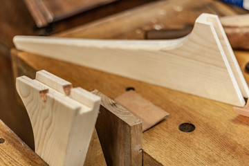 Eco friendly woodworker's shop. Details and focus on the texture of the material, saw dust, and planers or chisels, while making legs for a designer coffee table. Mastering wood with peacefullness.