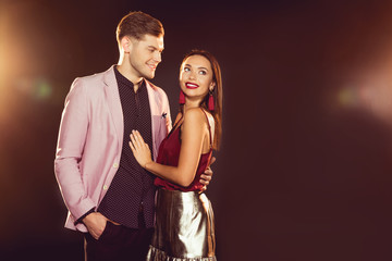 handsome man embracing happy girlfriend on new year party