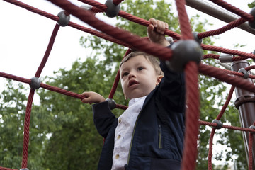 Obraz premium little boy playing in a rope park