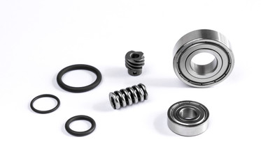 Close up view of set spare parts is bearing with tire ring and spring are small placed on white floor.