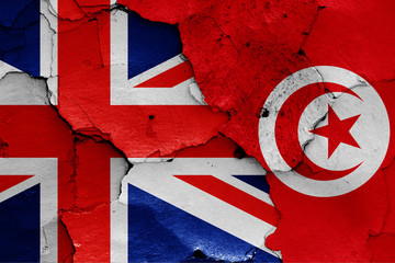 flags of UK and Tunisia painted on cracked wall