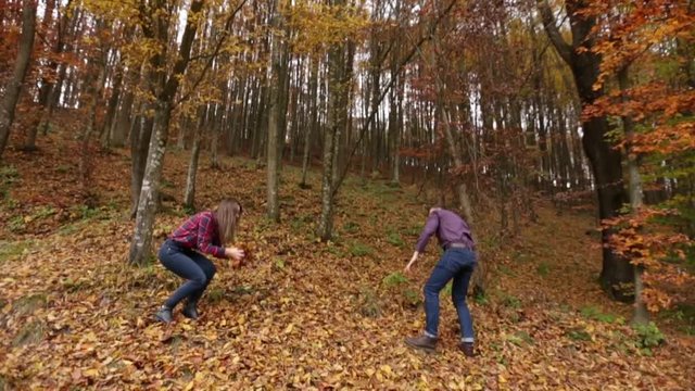 Boy and girl play with autumn leafs and have a goot time together