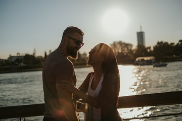 Couple laughing by the river in the sunset