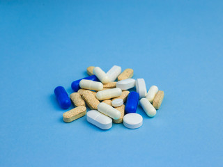 Assorted size and shape different pills on a blue background