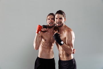 Fototapeta na wymiar Portrait of a two excited muscular shirtless twin brothers