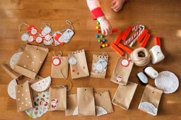 preparing the advent calendar. bags and sweets on the table. little baby arms to reach for the candy