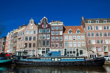 Naklejka premium Canals, boats and beautiful architecture at the Old Central district in Amsterdam