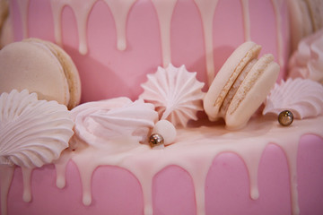 beautiful delicious birthday cake decorated with pink icing, meringues and marshmallows