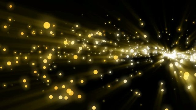 Gold glitter sparcles shiny flying on dark background.
